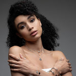 Inessa black ceramic lotus necklace styled with silver rings and bracelets, complete jewelry look