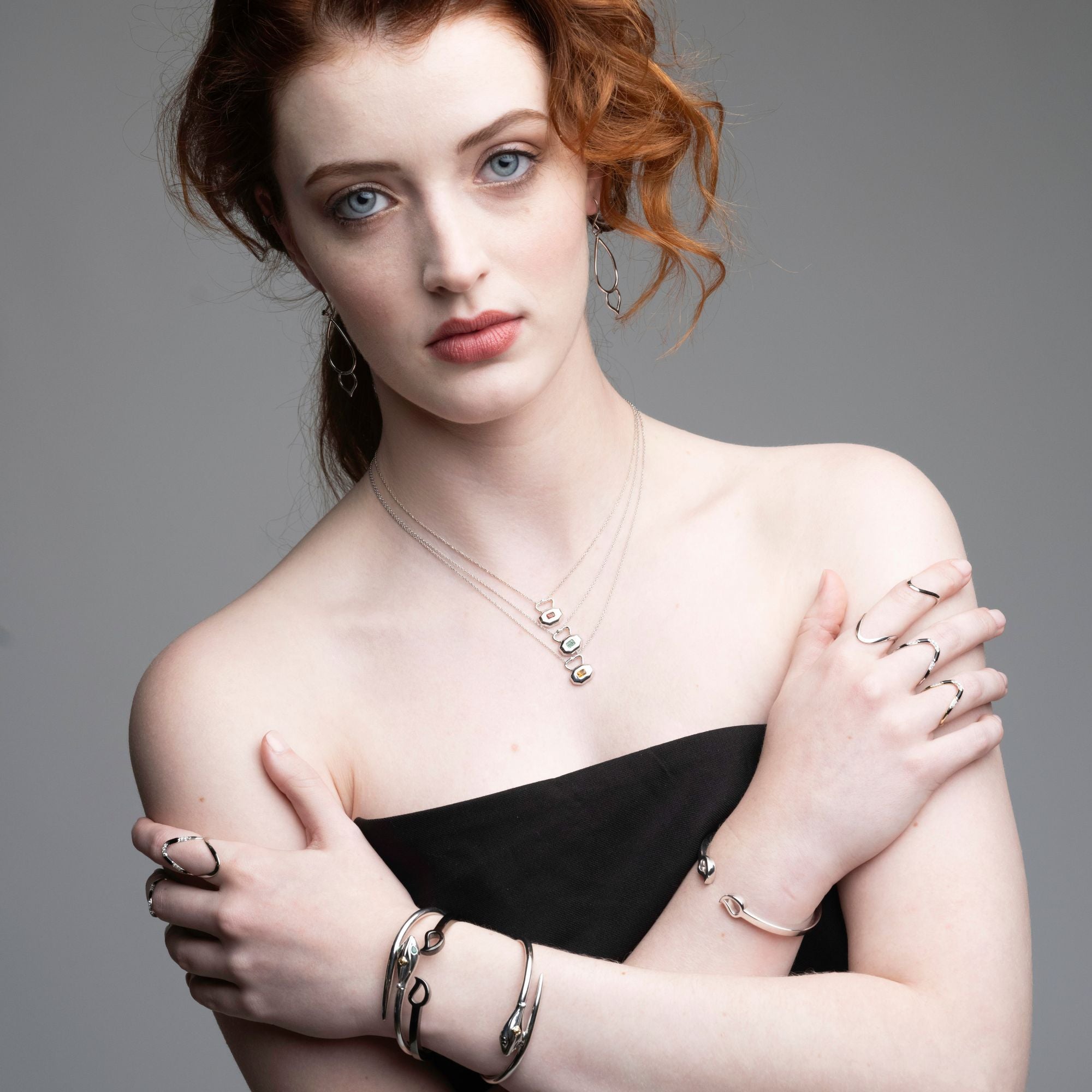 Model wearing birthstone lock necklaces with serpent rings and earrings displaying complete Inessa jewelry styling