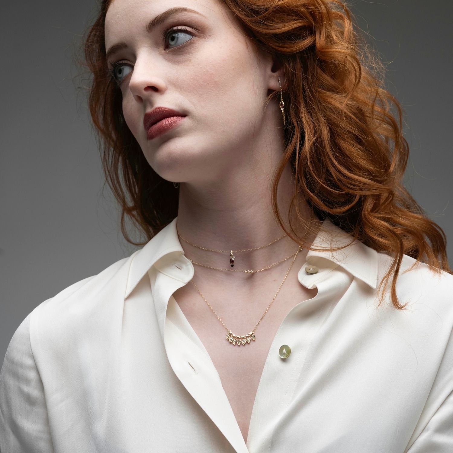 Professional woman wearing diamond trio layering necklace in 14k gold with layered chains
