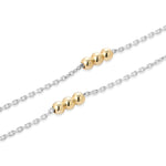 Close-up of Inessa mixed metal necklaces layered, 14k gold beads on rhodium silver chains