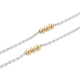 Close-up of Inessa mixed metal necklaces layered, 14k gold beads on rhodium silver chains