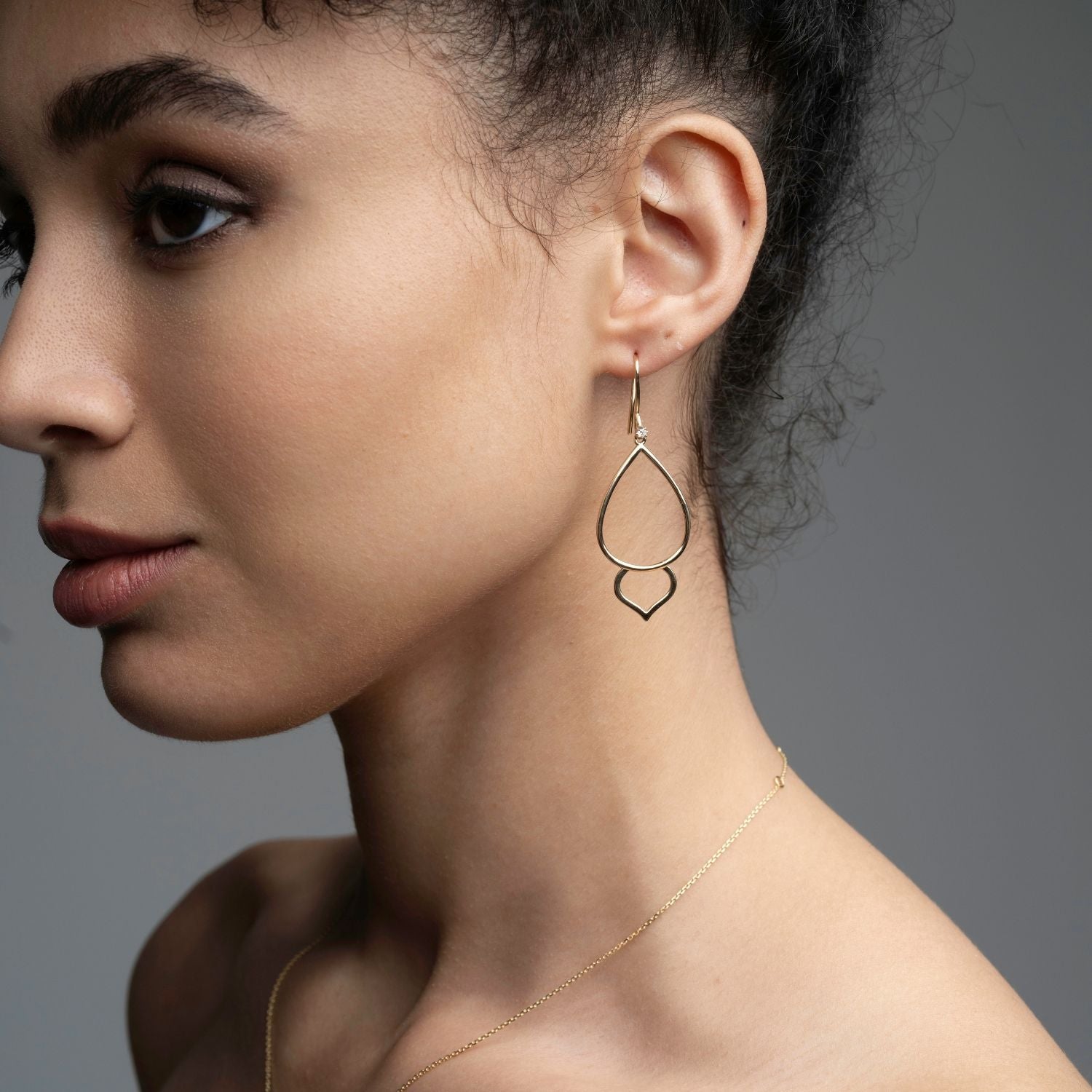 Profile view of 14k gold lotus bud hoop diamond earrings showing 53mm length and sculptural design