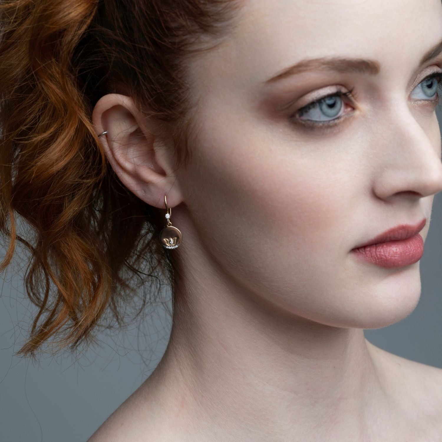 Woman wearing 14k gold lotus coin diamond earrings with matching ear cuff from Inessa Jewelry Strength Collection