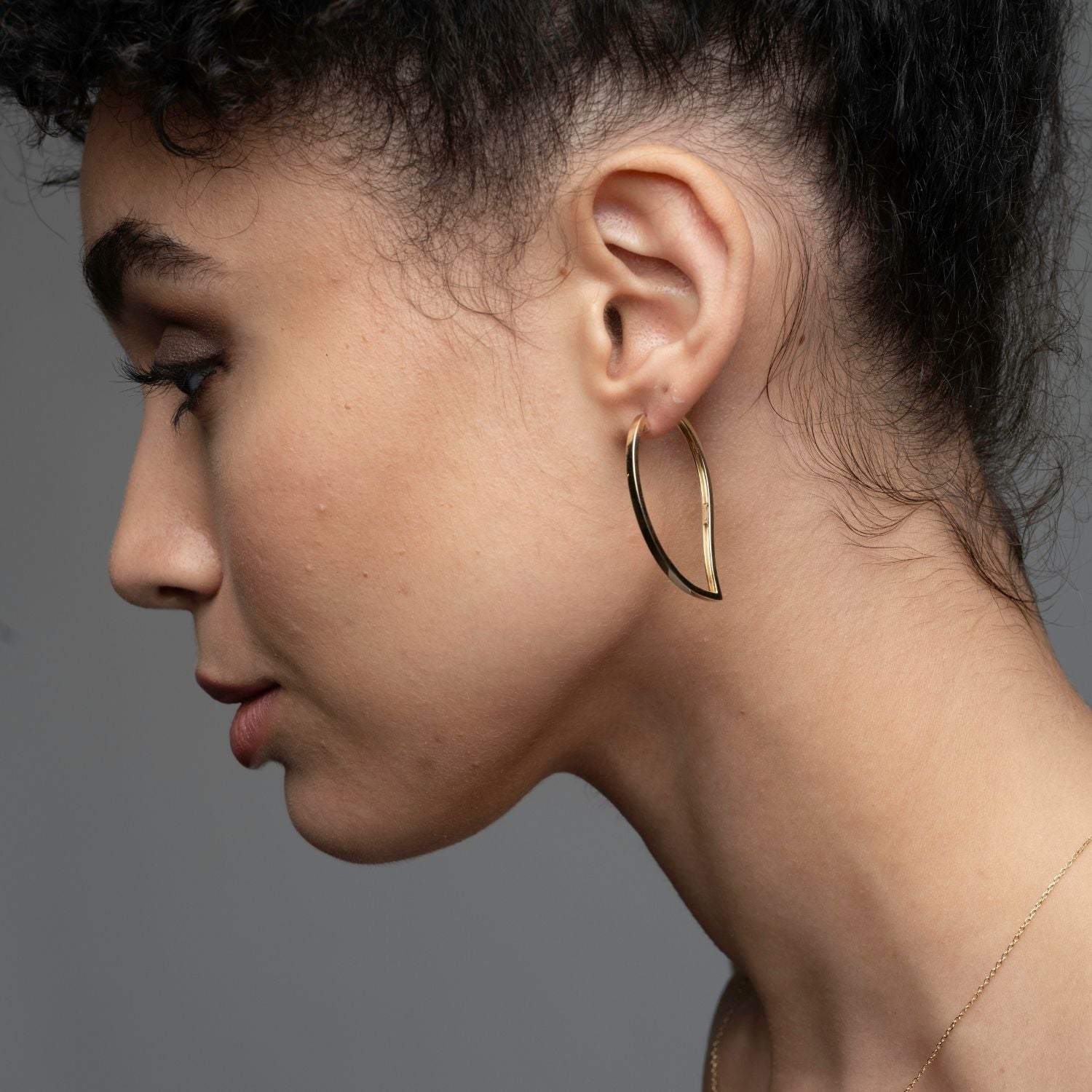 Side view of 14k gold mango hoop earrings showing sculptural shape and 40mm size