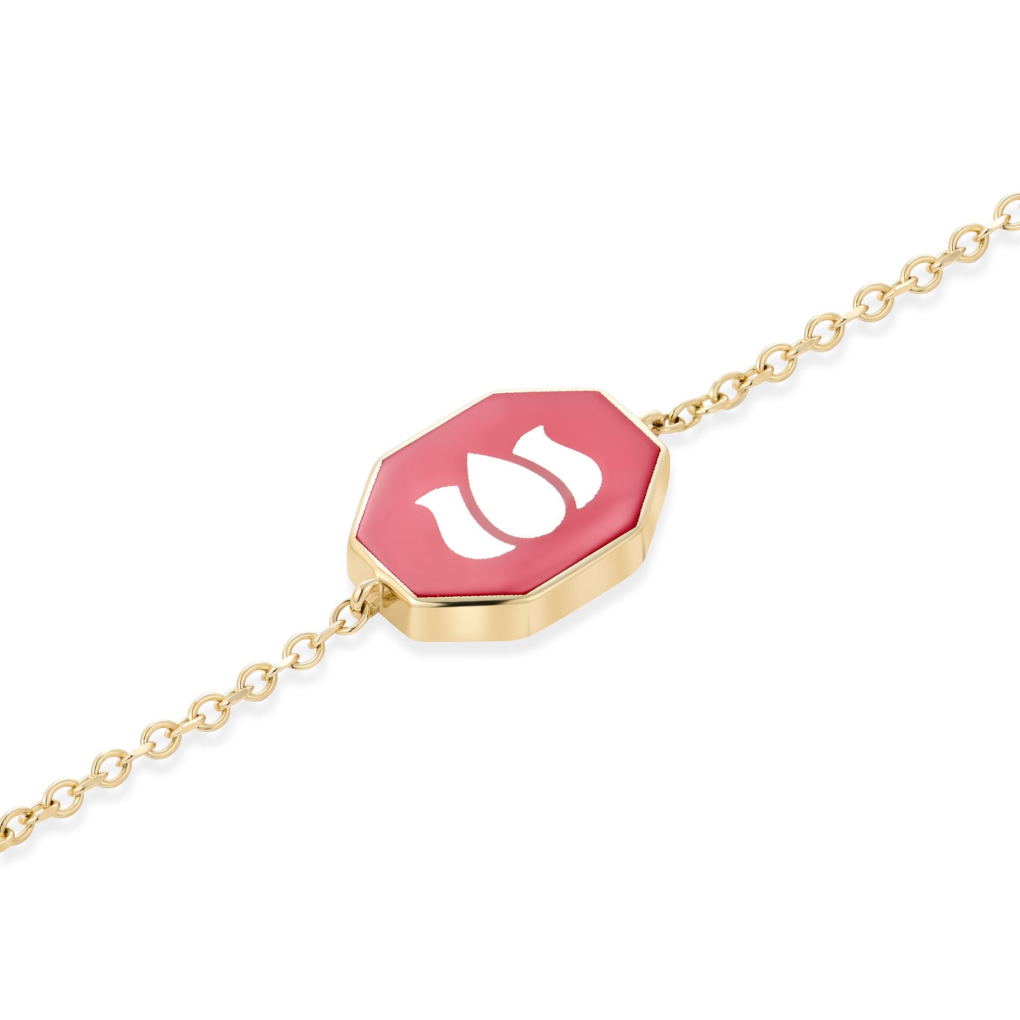 Double-sided maroon ceramic charm with white lotus symbol on 14k gold bracelet detail view