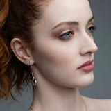 Woman wearing 14k gold serpent chain drop earrings with emerald eyes from Inessa Renewal Collection