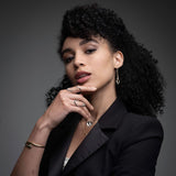 Professional woman wearing 14k gold serpent chain drop earrings for boardroom presentation look