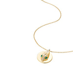 Angled view of serpent coin pendant necklace showing dimensional design and natural chain drape