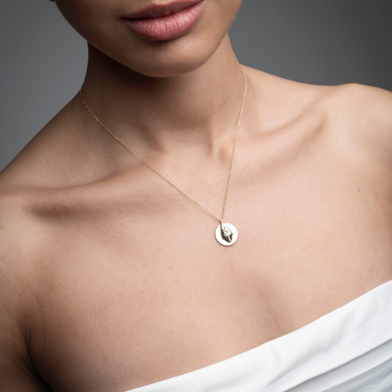 Woman wearing 14k gold serpent coin pendant necklace from Inessa Renewal Collection