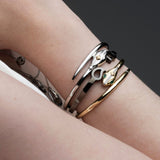 Stacked serpent hinged bangles in sterling silver and 14k gold from Inessa Renewal Collection