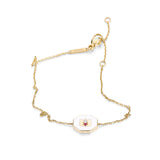 White ceramic lotus symbol bracelet with tourmaline accents arranged elegantly on white background
