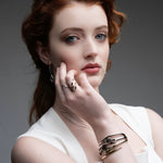 Professional woman wearing 14k gold wave ring with black ceramic and diamonds