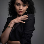 Woman wearing 14k gold wave statement ring with black and white diamonds from Inessa Confidence Collection