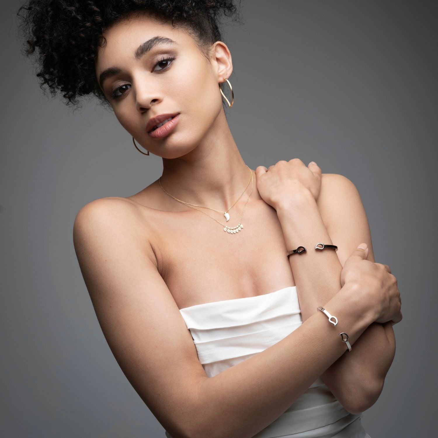 Woman wearing mango silver bracelet with layered necklaces and hoops from Inessa Love Collection